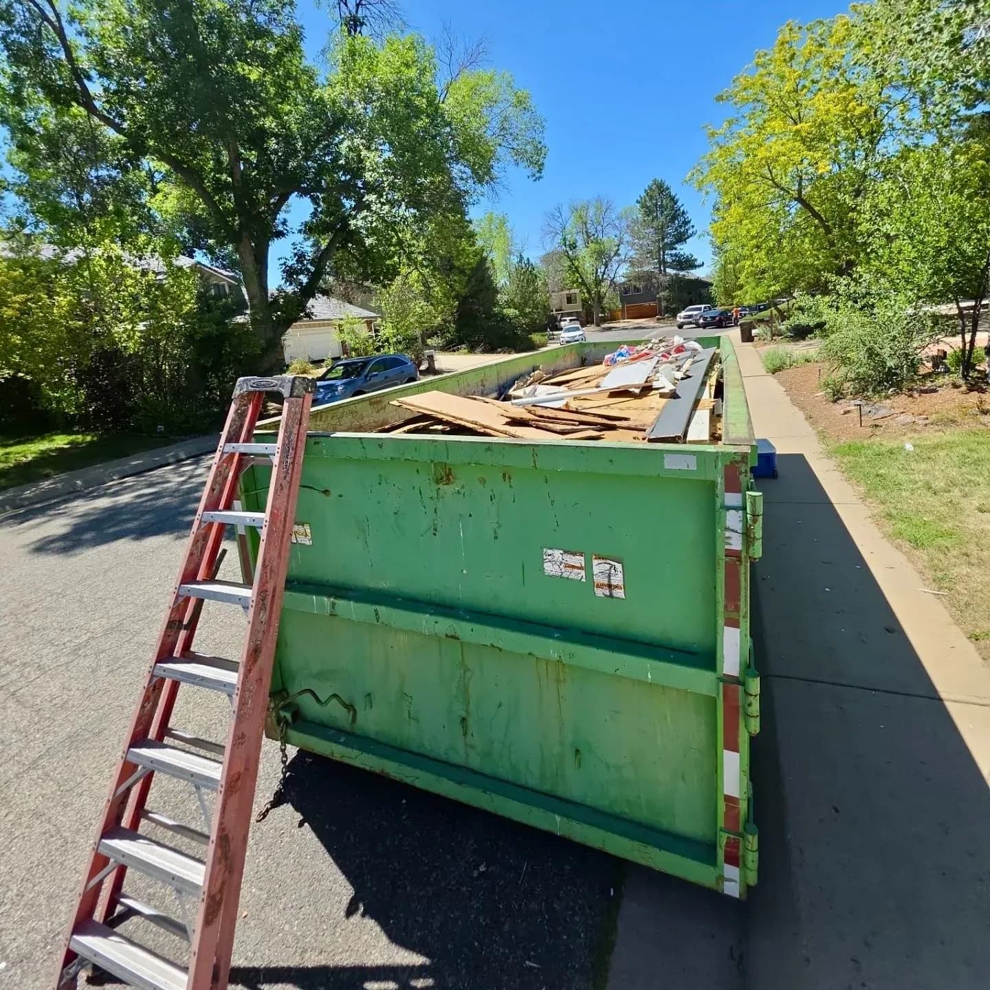 A dumpster filled with old siding torn off during a siding replacement project in Boulder, CO.