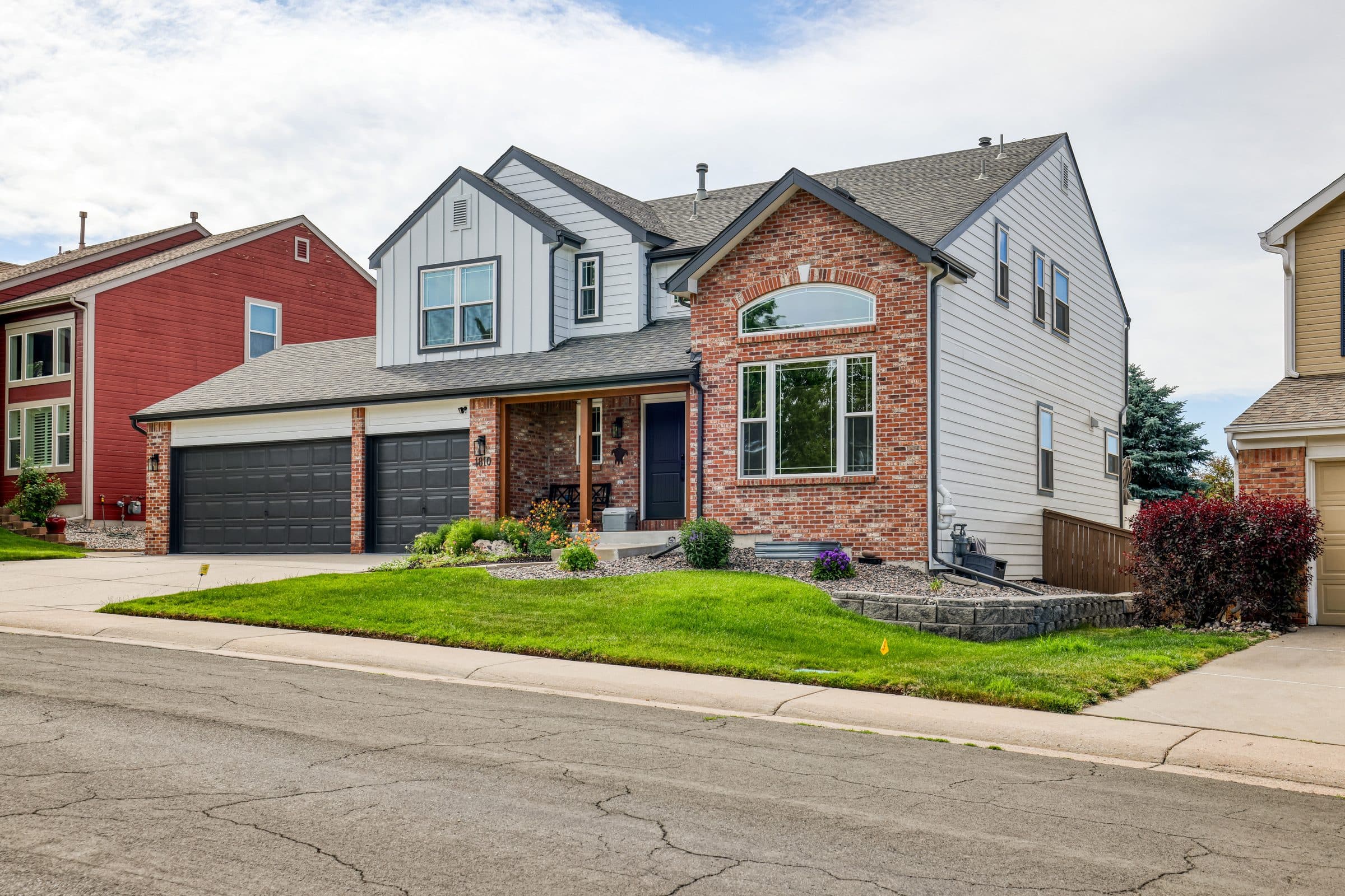 Littleton, CO home with lap siding and board-and-batten gables above a brick front
