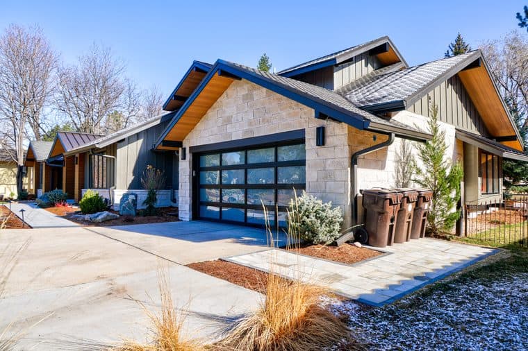 Boulder Colorado home after full exterior remodel with James Hardie fiber cement siding, El Dorado stone veneer, metal roof, Pella bi-fold and sliding patio doors, and new garage door