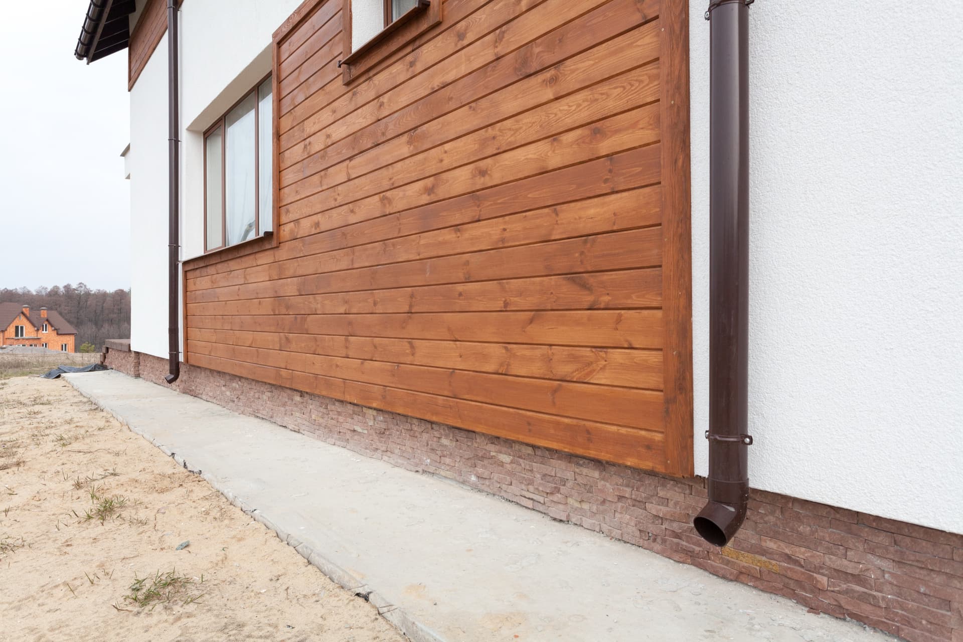 Natural wood lap siding with warm cedar stain finish on a residential home exterior