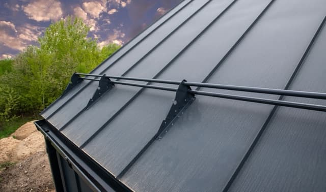 Snow guard retention bars installed on standing seam metal roof