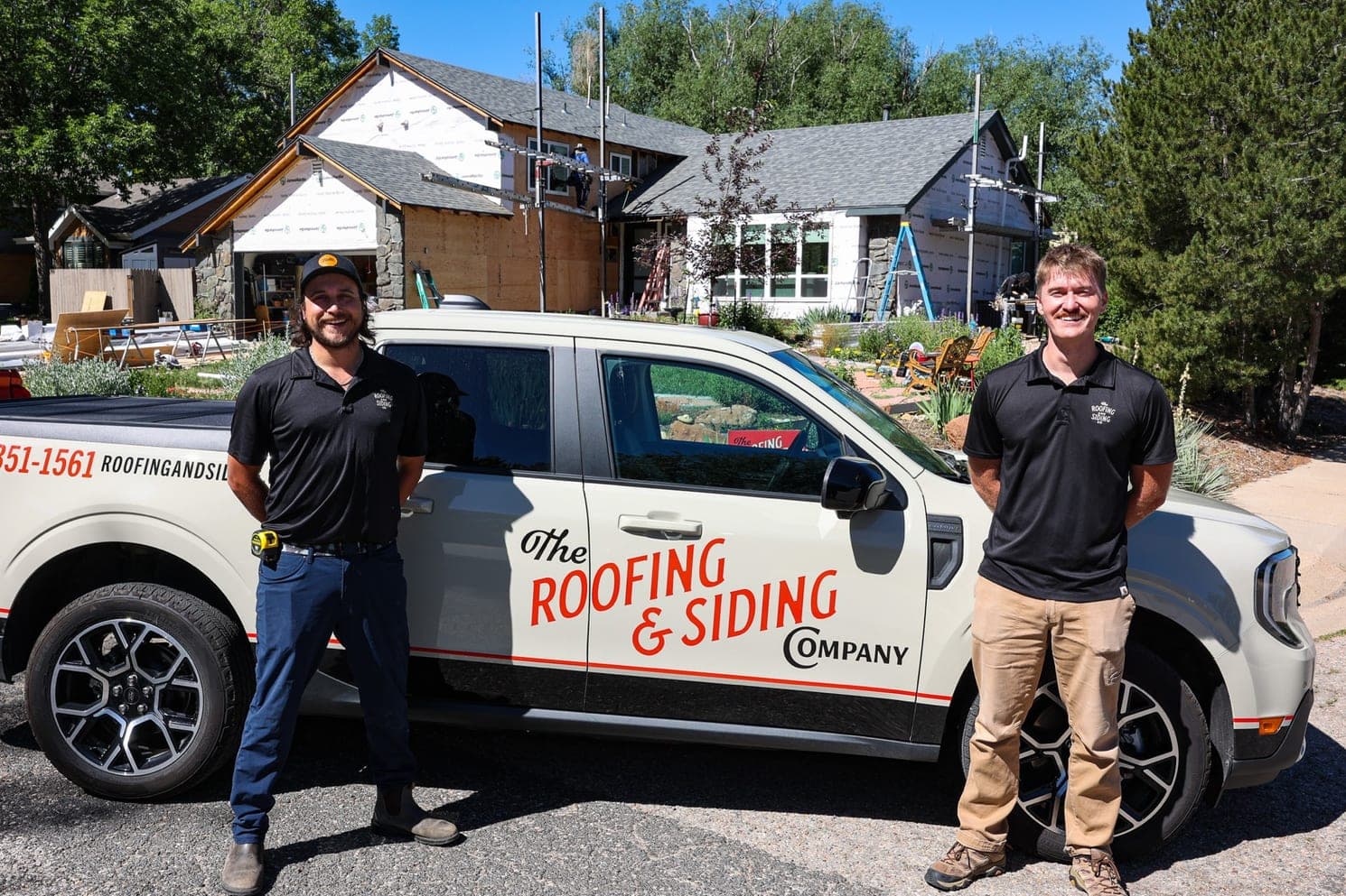 The Roofing & Siding Company team standing by their branded truck at a job site in Boulder, Colorado