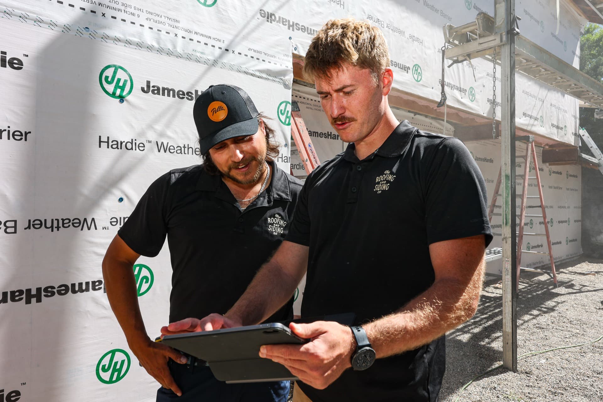 Jack and Cole from The Roofing & Siding Company reviewing a project at a job site in Boulder, Colorado