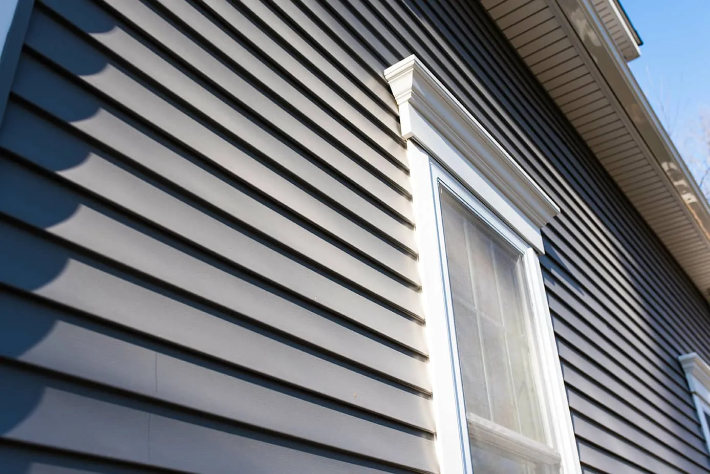 Window with white trim on blue siding Denver home