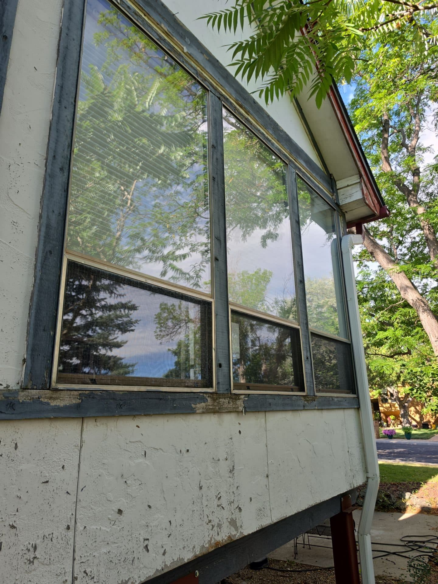 Old deteriorated siding and windows on a home in Arvada, CO.