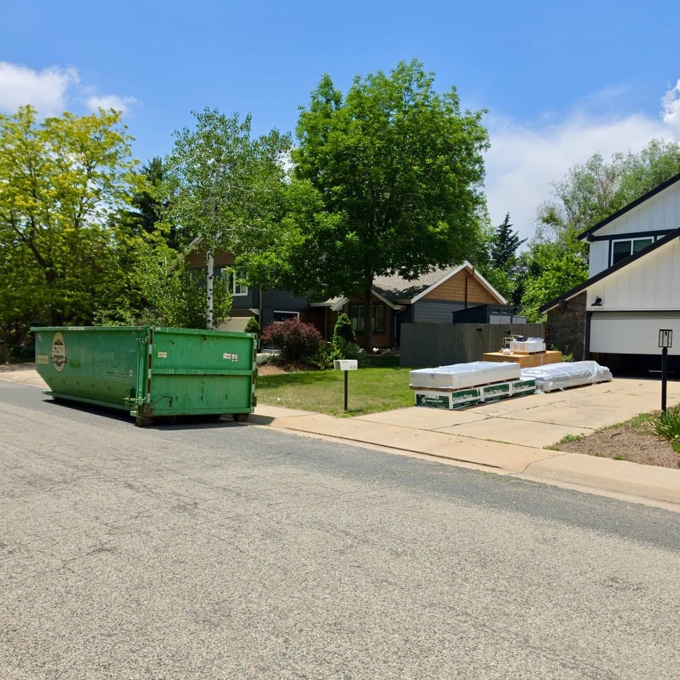 Dumpster and material delivered to a home at the start of a siding replacement project in Boulder, CO.