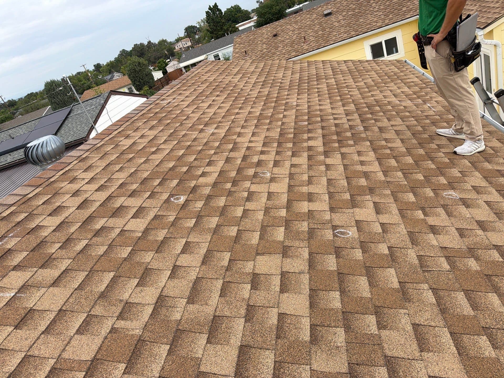 A roof with many white chalk marks indicating hail damage in Commerce City, Colorado.