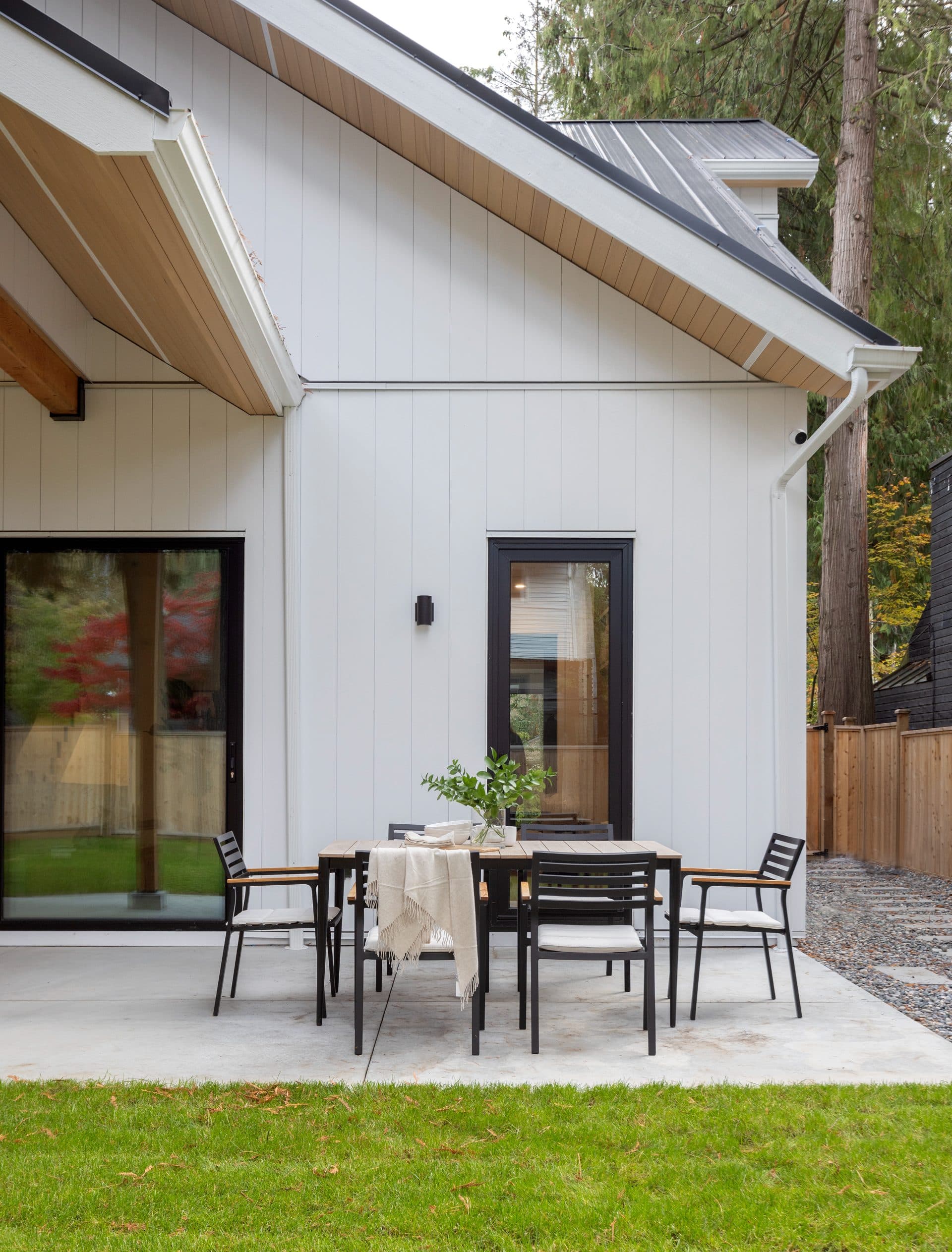 James Hardie Arctic White siding on a beautiful home with a dining set on the patio.