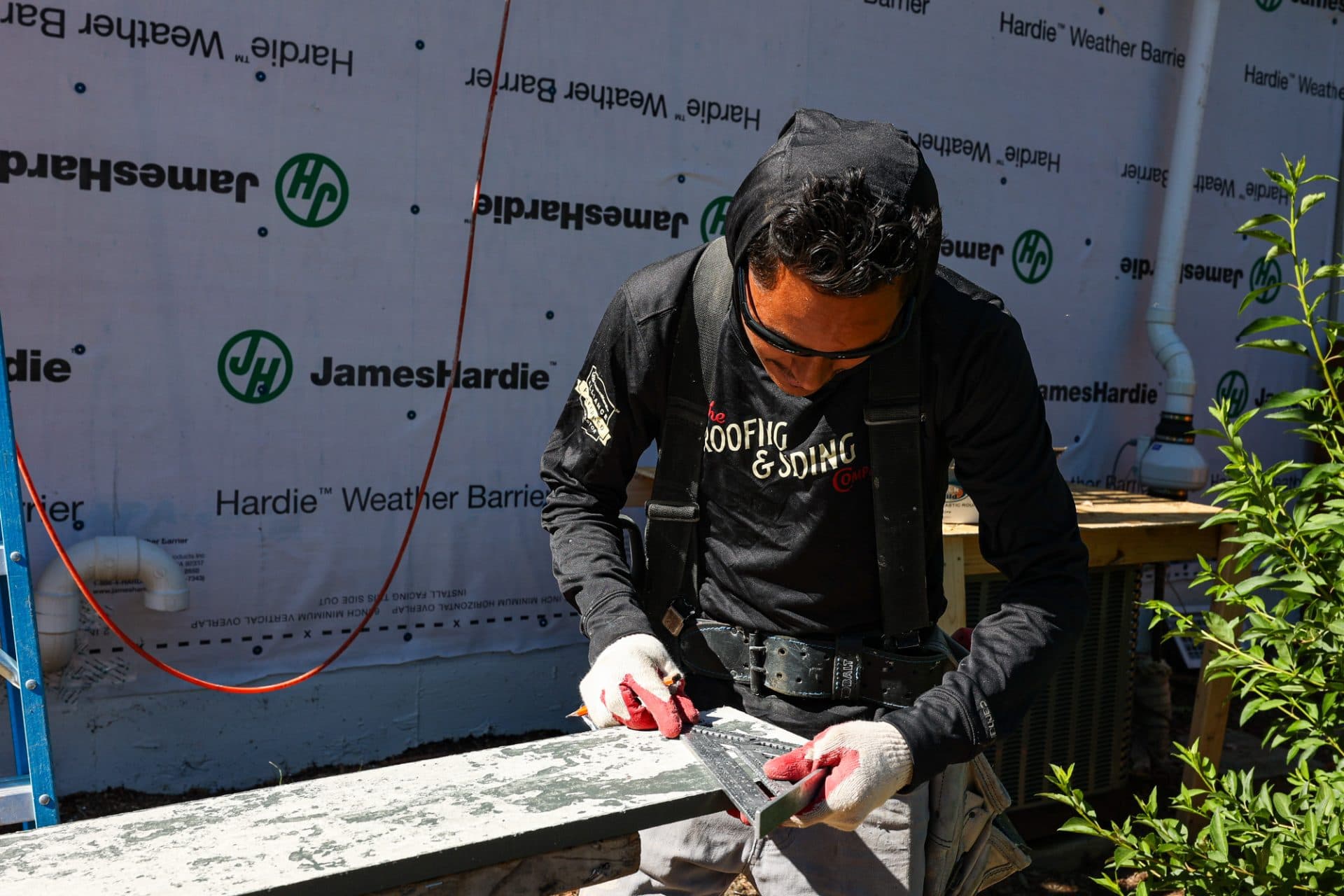 The Roofing & Siding Company crew measuring and cutting james hardie siding in Boulder, CO.