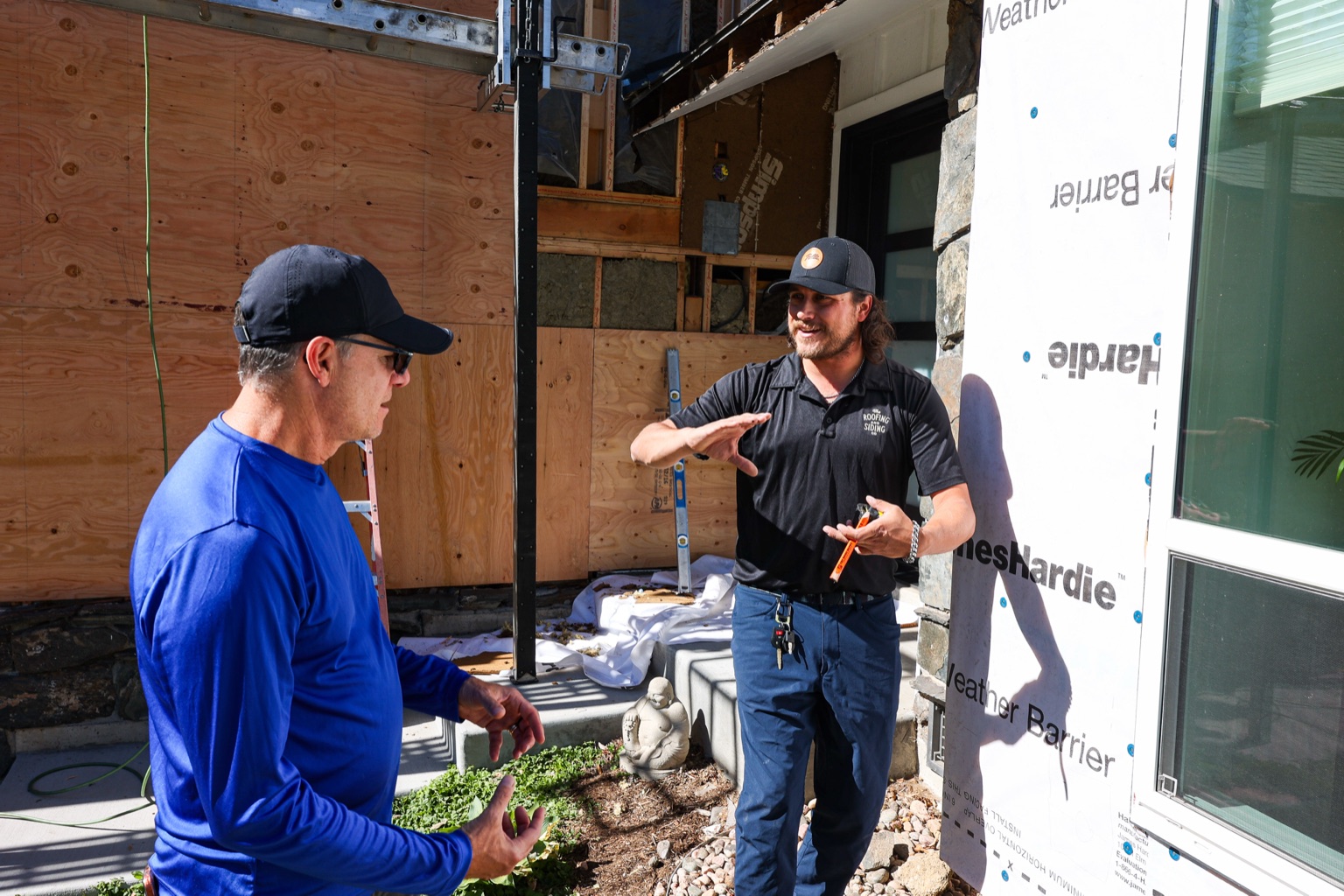 Bobby and a Roofing & Siding Company team member reviewing project progress in front of the home in Boulder, CO